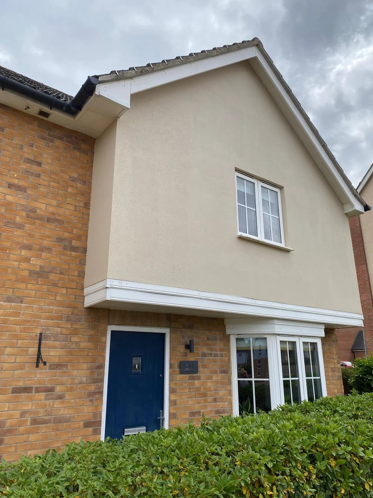 Repainted exterior render with a blue front door